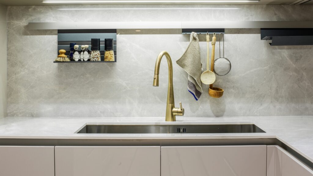 A contemporary kitchen with an undermount sink and golden fixtures