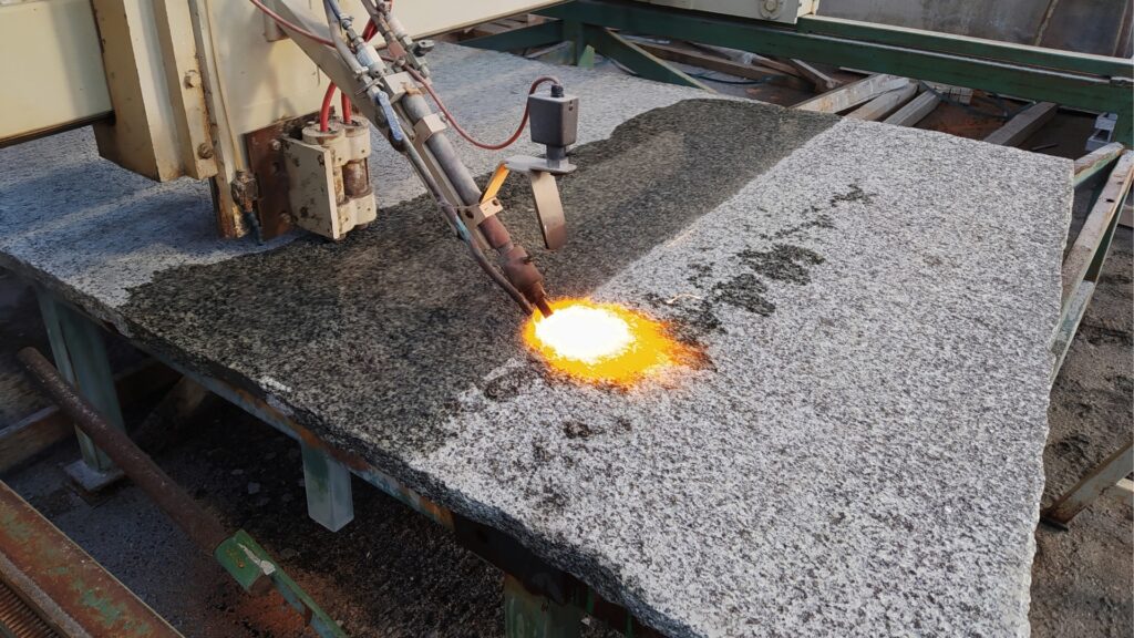 Machine used to achieve a flamed granite surface finish